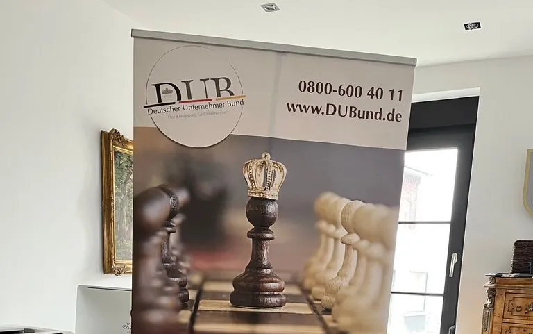 Roll-up des DUB mit Logo, Telefonnummer und Schachfigur mit Krone