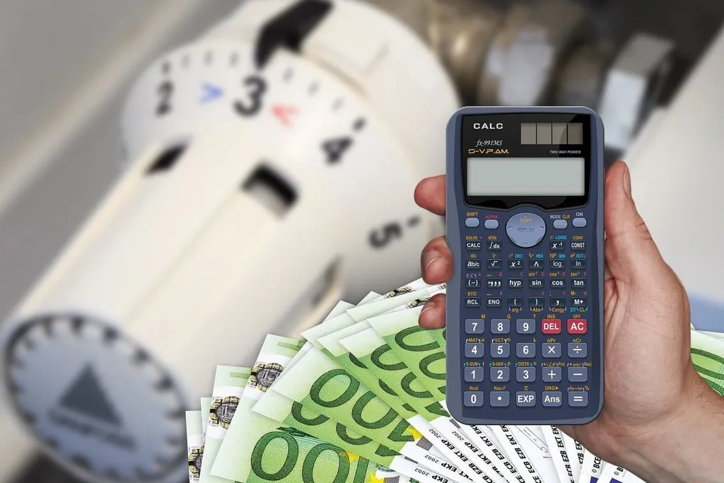 Hand mit Taschenrechner vor einem Heizungsthermostat und Geldscheinen