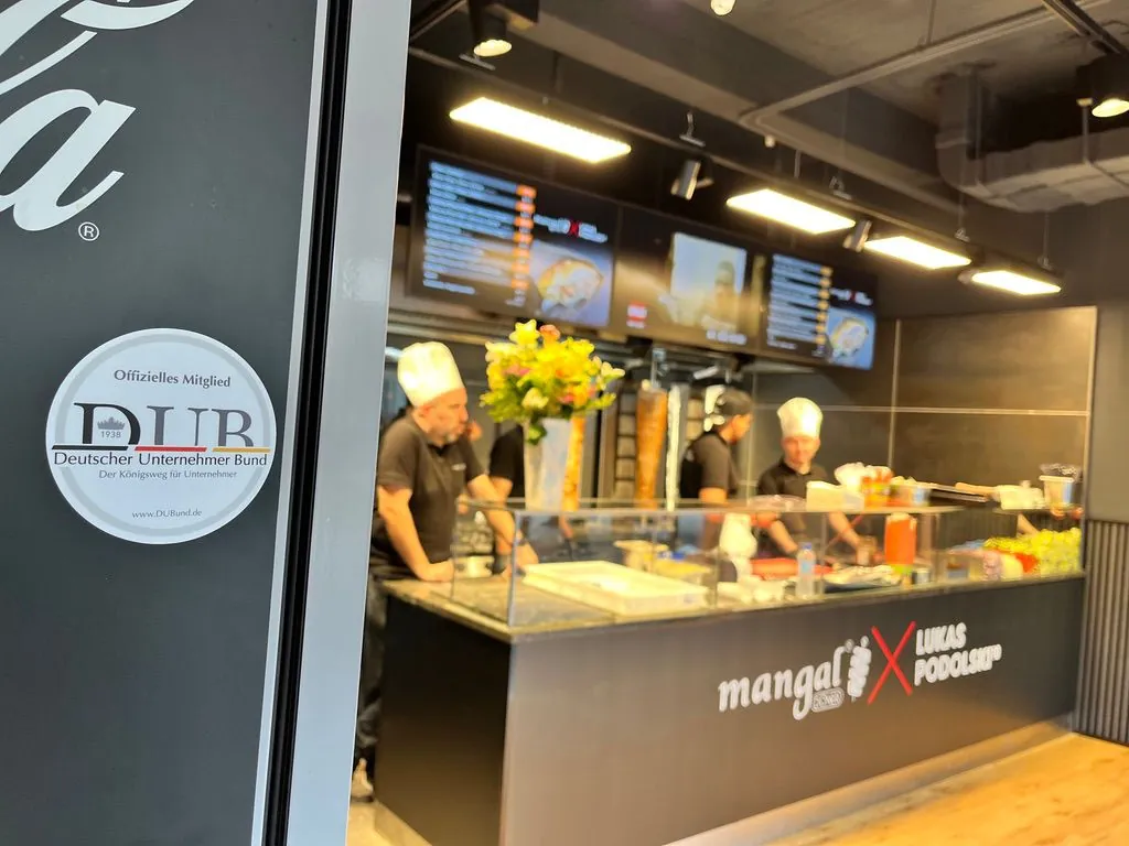 Open kitchen of a fast-food restaurant with a plaque on the wall