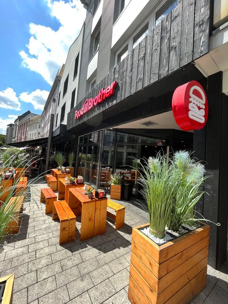 Outdoor terrace of a burger restaurant with wooden benches